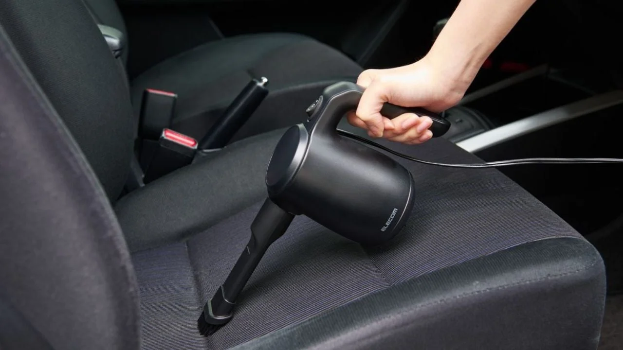 車のシートをハンディクリーナーで掃除する様子