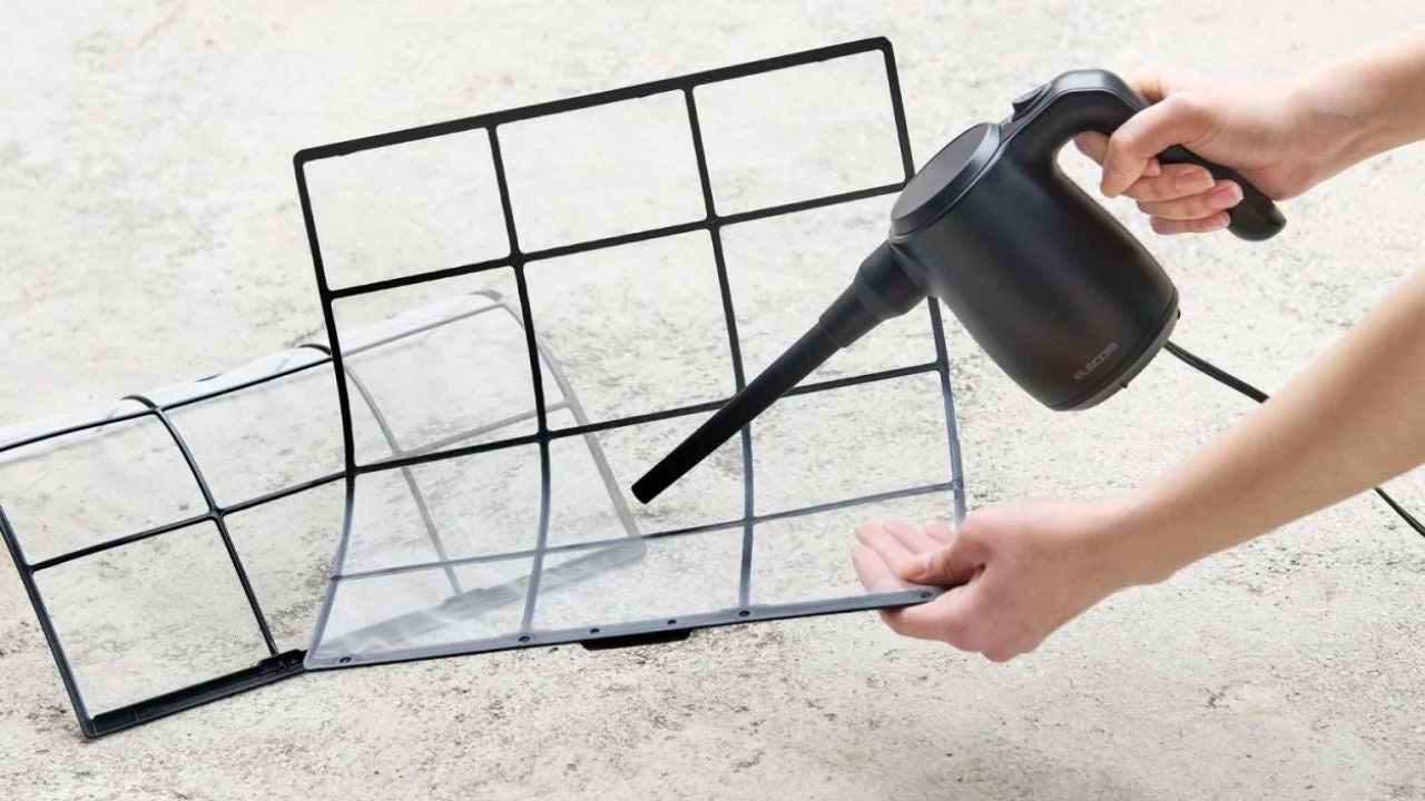 エアコンフィルターを電動エアダスターで掃除する様子