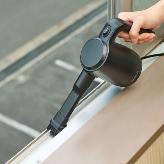 窓のサッシをブラシノズルで掃除する様子